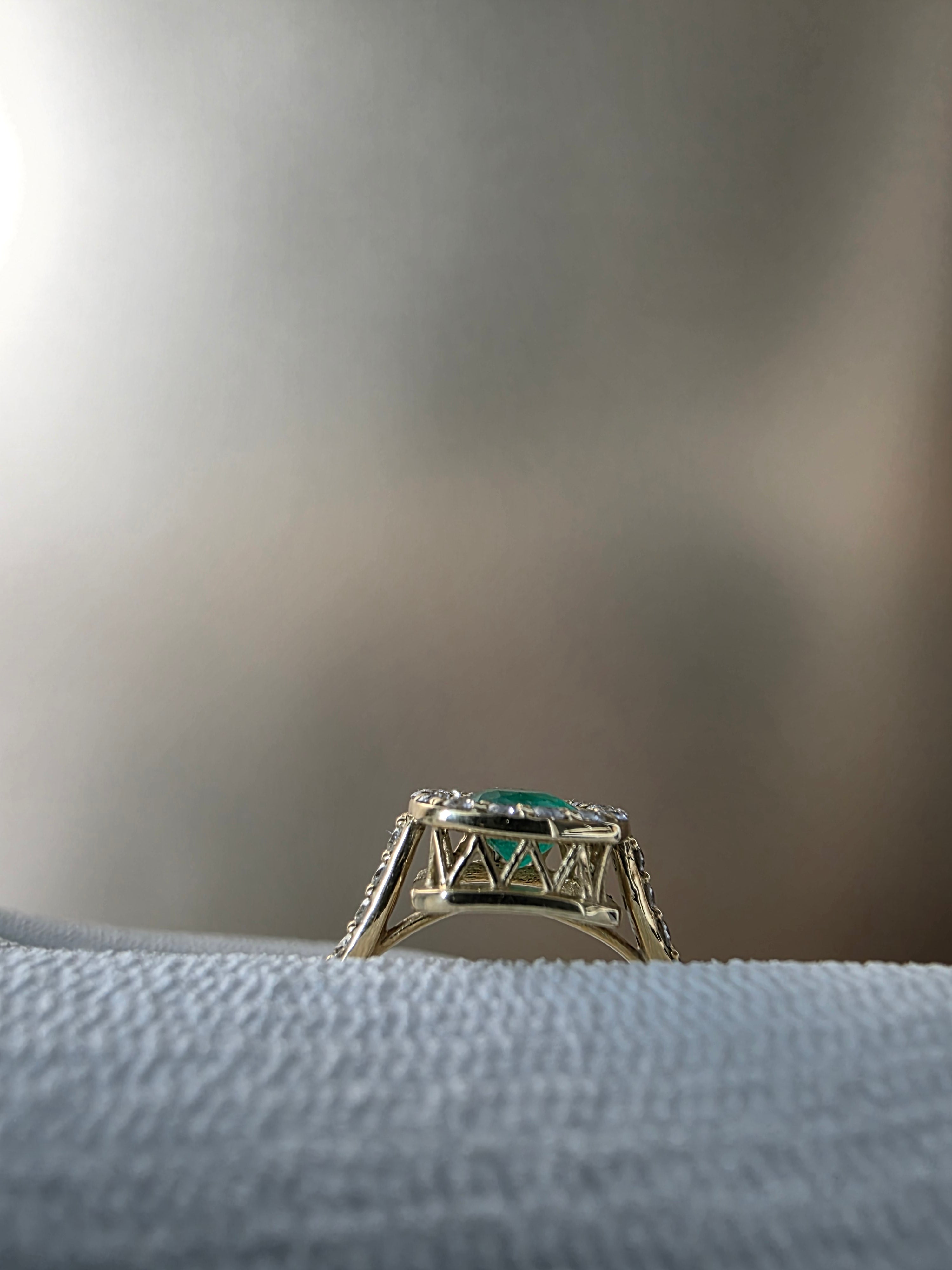 0.62 CT cushion Emerald with diamond halo ring