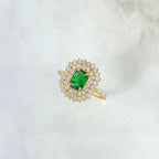 Gold ring with a green gemstone on a white background