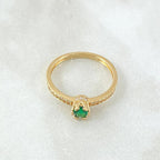 Gold ring with a green gemstone on a white background