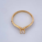 Gold ring with a diamond on a light gray background