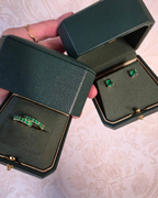 Green jewelry box with emerald green gemstone jewelry on a textured surface