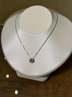 Necklace with a pendant on a white mannequin bust against a wooden background