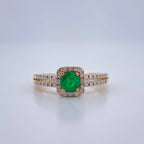 Ring with a green gemstone and diamond accents on a light gray background