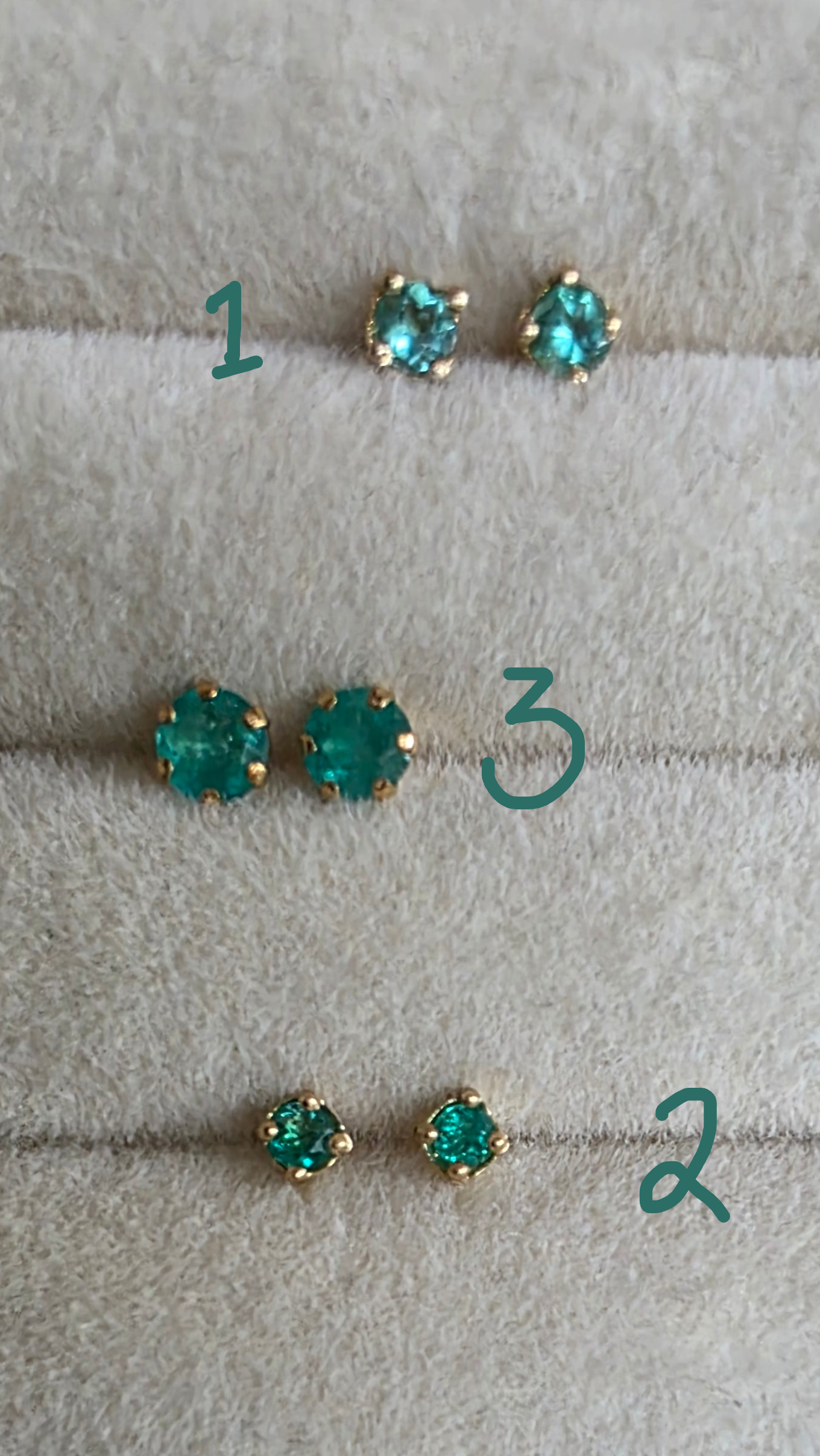 Pair of turquoise stud earrings on a light gray surface