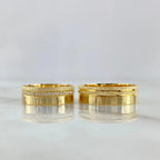 Two gold rings with diamond accents on a light gray background