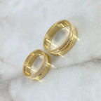 Two gold rings with diamond accents on a marble surface