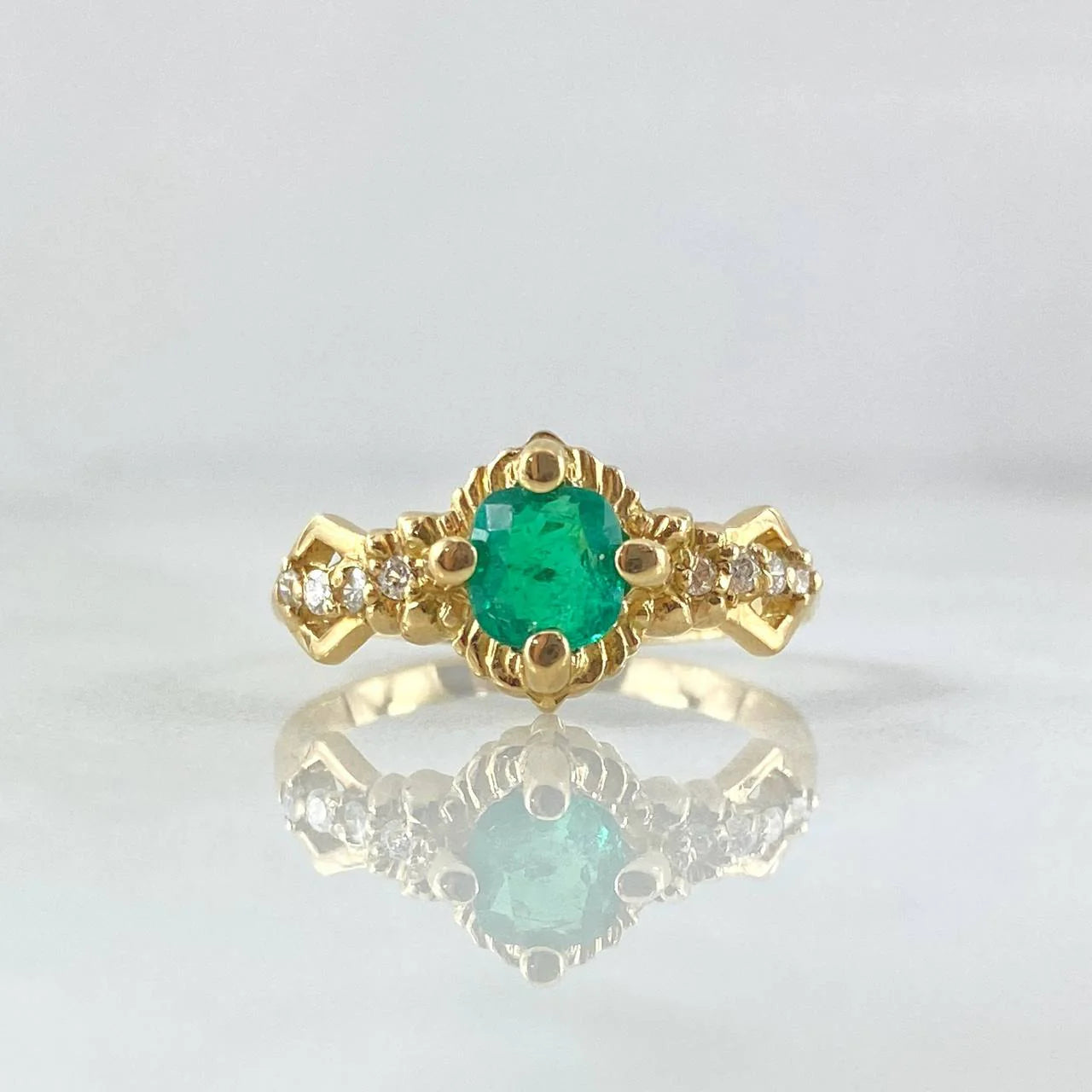Round emerald engagement ring foundation with crown-style head and tapered diamond shoulders.