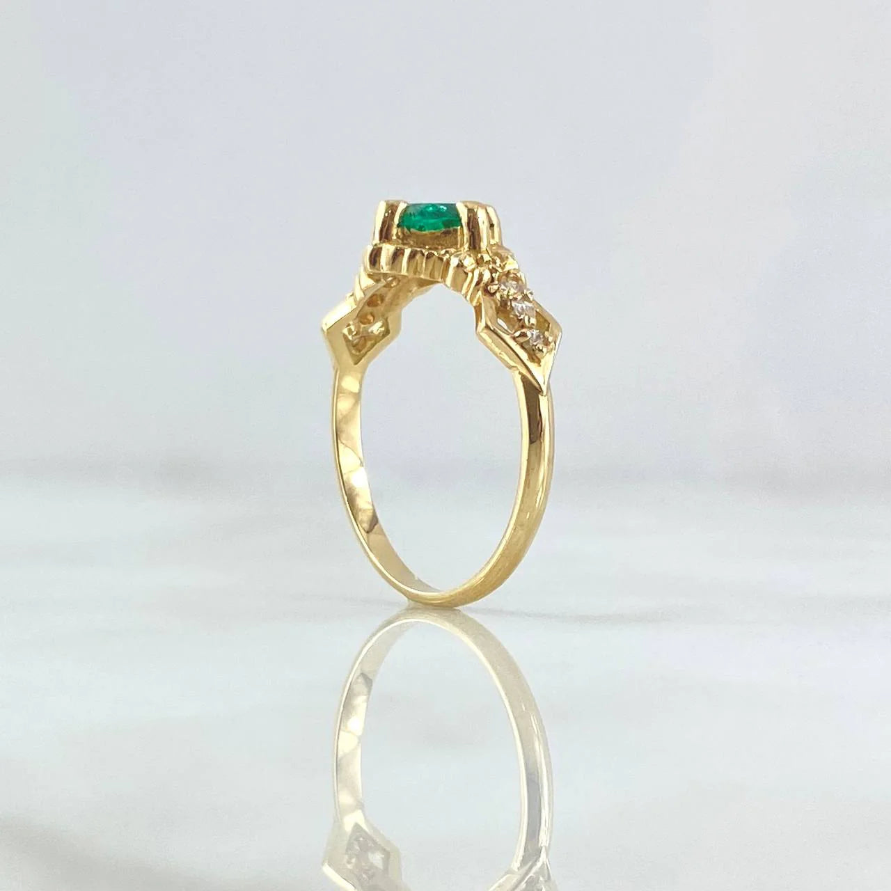 Round emerald engagement ring foundation with crown-style head and tapered diamond shoulders.
