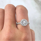 Hand wearing a diamond ring with a blurred background