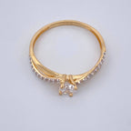 Gold ring with a diamond on a light gray background