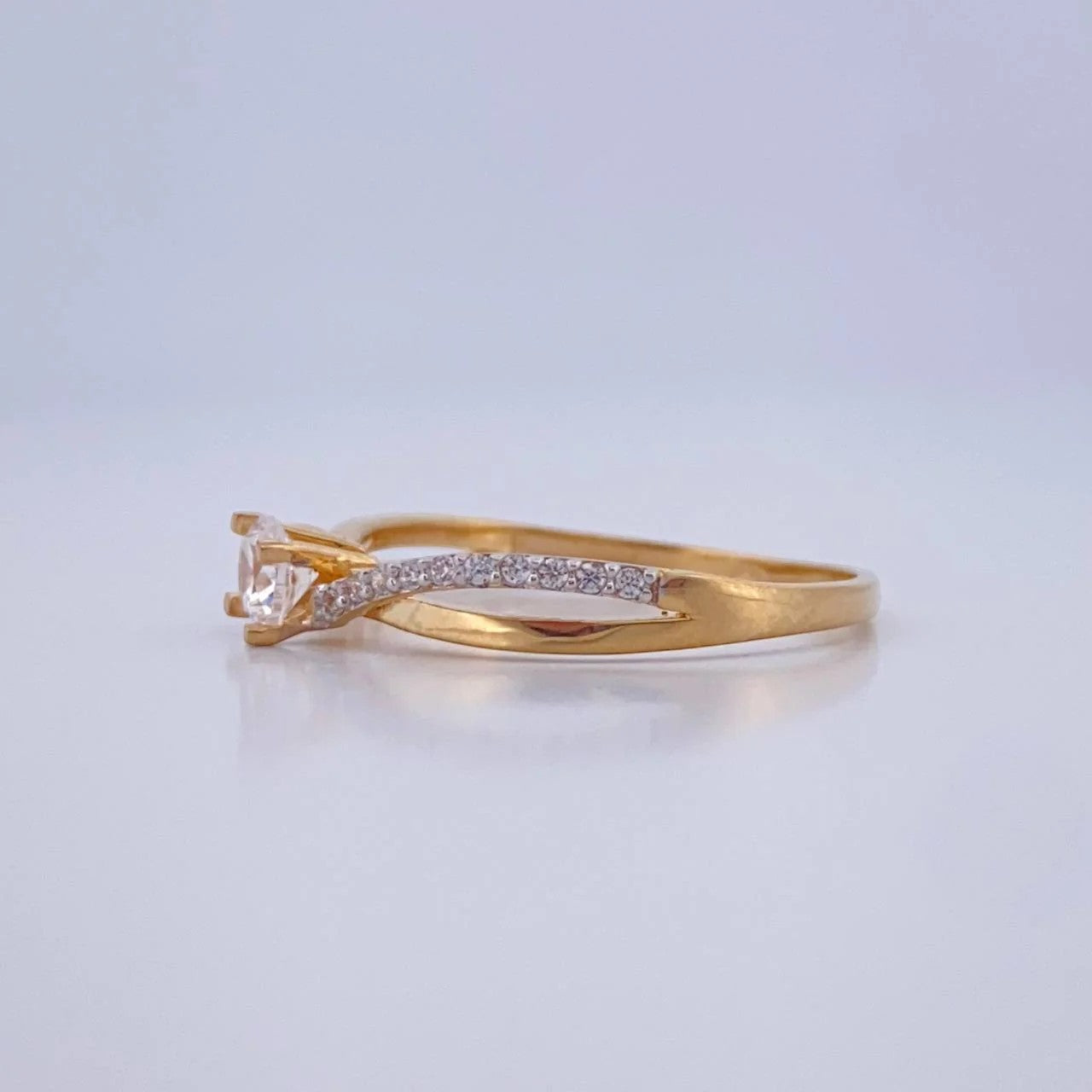 Gold ring with diamonds on a light gray background
