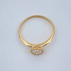 Gold ring with a diamond on a light gray background