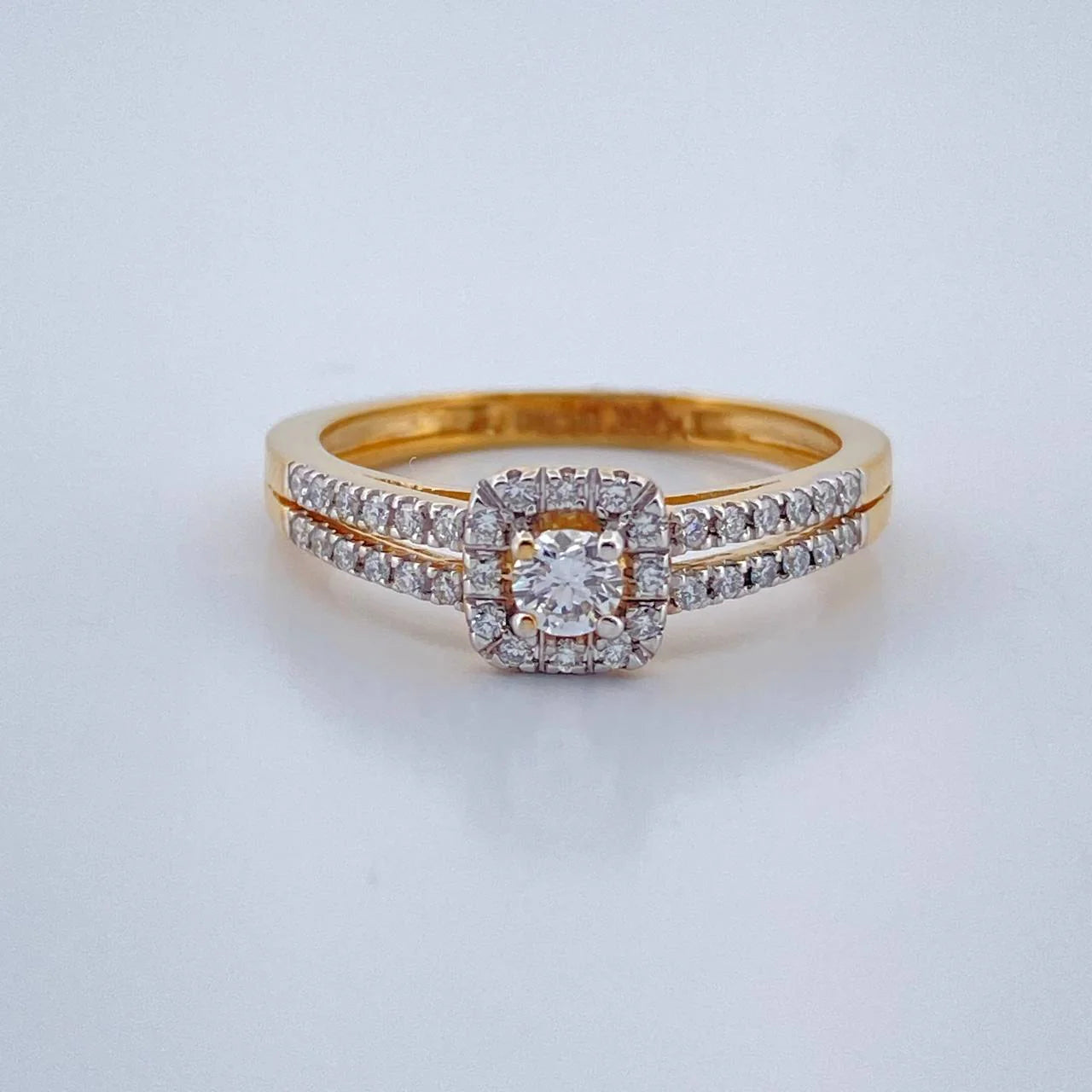 Gold ring with a diamond on a light gray background