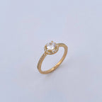 Gold ring with a diamond on a light gray background