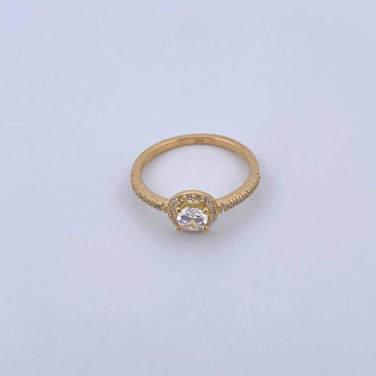 Gold ring with a diamond on a light gray background