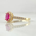 Gold ring with a pink diamond on a white background