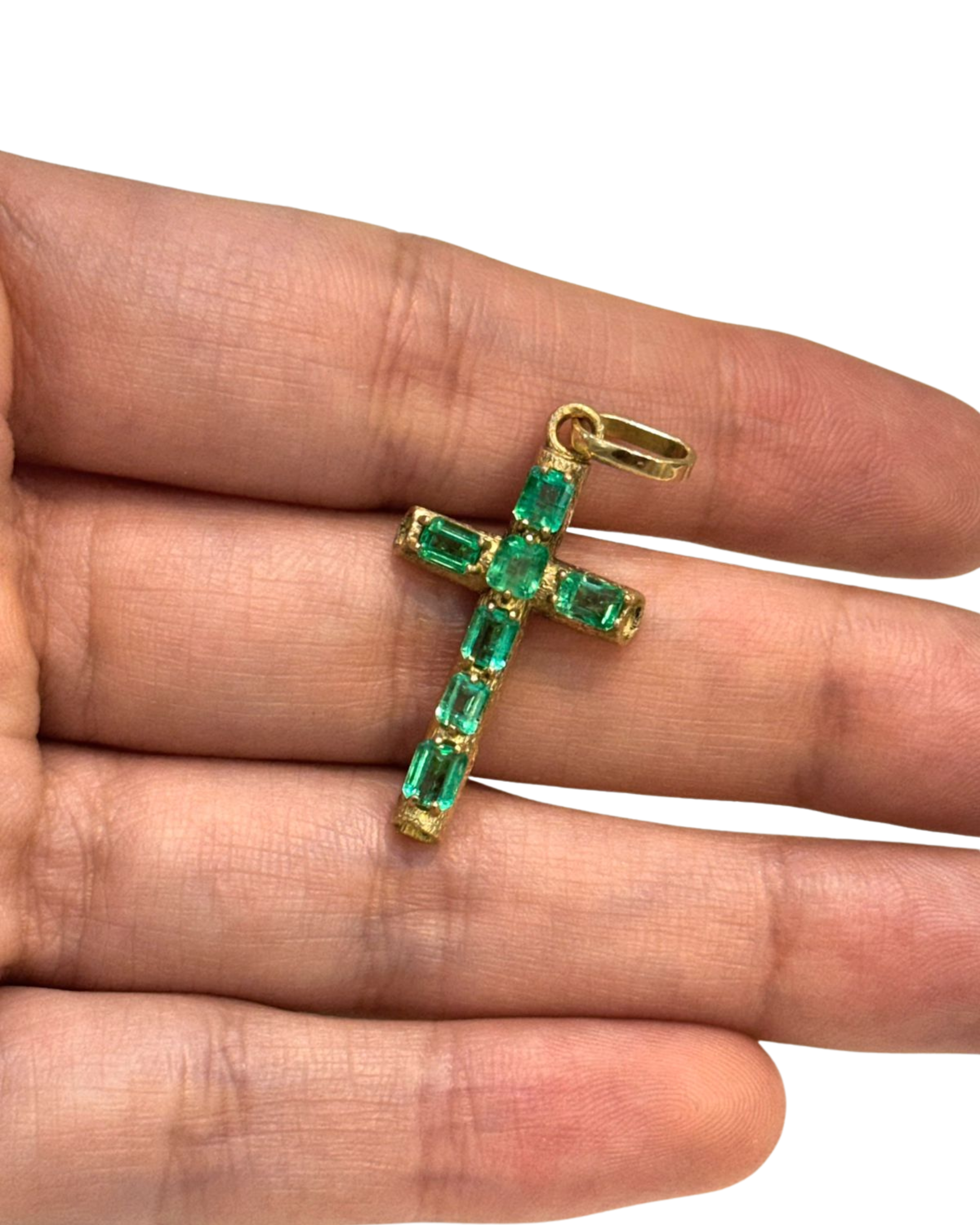 close-up of emerald cut Colombian emeralds set in 18K gold cross pendant, held in hand | Gado Jewellers, fine Canadian jewellery
