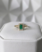 emerald cut Muzo emerald ring with diamond halo in 18K gold, displayed on ring box | Gado Jewellers, fine Canadian jewellery
