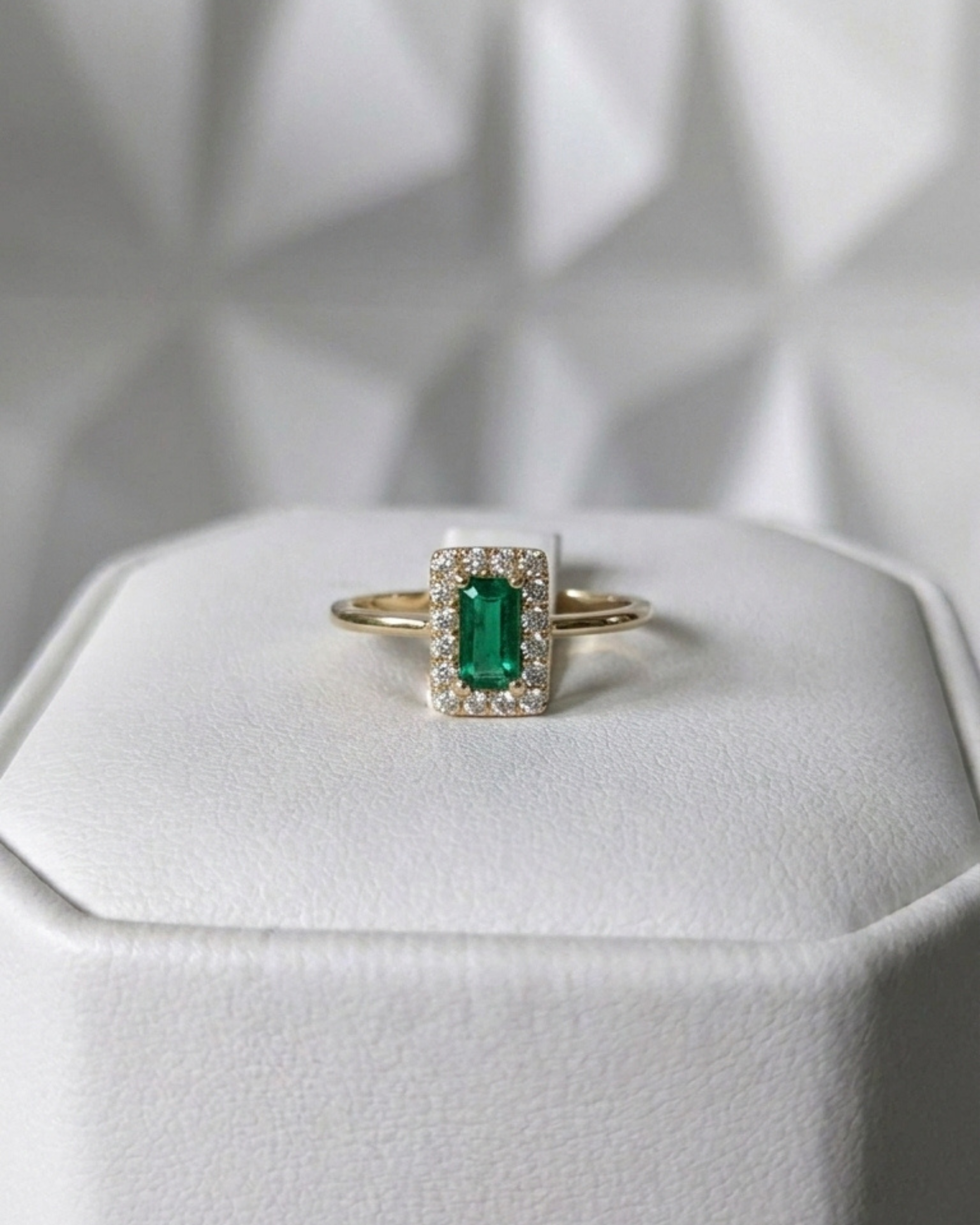 emerald cut Muzo emerald ring with diamond halo in 18K gold, displayed on ring box | Gado Jewellers, fine Canadian jewellery