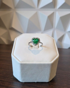 heart cut Muzo emerald ring with diamond halo in white gold, displayed on ring box | Gado Jewellers, fine Canadian jewellery