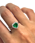 heart cut Muzo emerald diamond halo ring in white gold worn on hand | Gado Jewellers, fine Canadian jewellery
