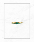 Anillo solitario con línea de esmeraldas