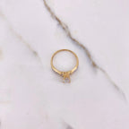 Gold ring with a diamond on a marble surface