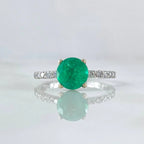 Anillo solitario redondo: esmeralda, diamantes y oro blanco.