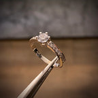 Three-piece white gold bridal set featuring a round diamond engagement ring with pavé shoulders, paired with two layered channel wedding bands in 18K gold.