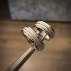 Three-piece white gold bridal set featuring a round diamond engagement ring with pavé shoulders, paired with two layered channel wedding bands in 18K gold.