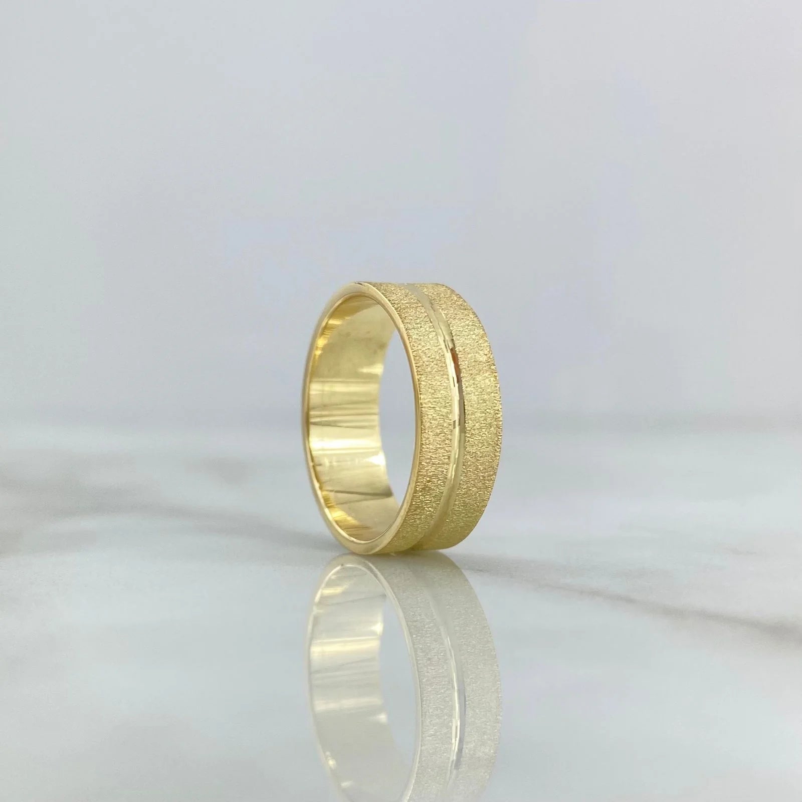 Brushed 18K gold wedding band with a continuous polished channel and rounded comfort profile.