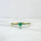 Gold ring with green gemstone on a white background