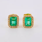 Pair of emerald green gemstone earrings with gold and diamond accents on a white background