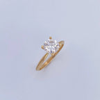 Gold ring with a diamond on a light gray background