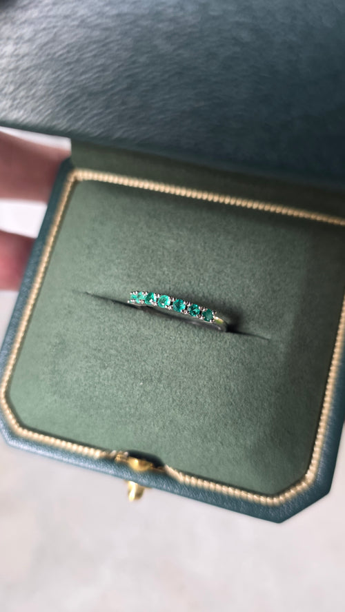 Colombian emerald band ring in 18K white gold, set in a Gado green ring box, styled studio shot | Gado Jewellers Mississauga Ontario Fine Jewellery