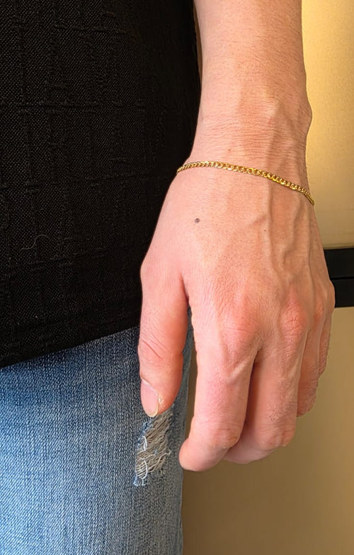 Cuban curb link bracelet in 18K gold worn on wrist | Gado Jewellers Fine Jewellery Mississauga