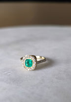 cushion cut natural colombian emerald center stone, natural diamond halo, engagement ring in 18K yellow gold, studio shot in signature Gado packaging, fully certified gemstones and gold purity | Gado Jewellers Toronto Fine Jewelry Custom Engagement Rings