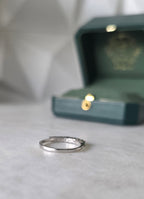 Colombian emerald band ring flat lay, round-cut emeralds, 18K white gold, Gado Jewellers