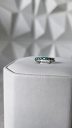 Natural Colombian emerald band ring on display stand, 18K Italian white gold, Gado Jewellers