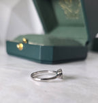 Side profile of Colombian emerald diamond halo ring in 18K white gold by Gado Jewellers